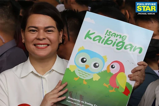 Vice President Sara Duterte holding her self-authorized book, “Isang Kaibigan”